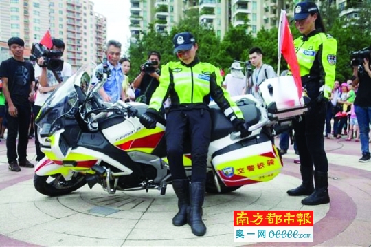 个头娇小的女队员轻松顶起了倒下的摩托车.